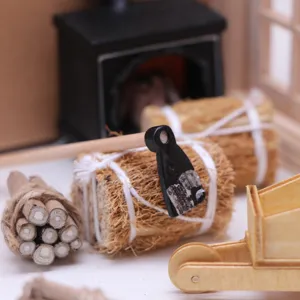 Dollhouse winter scene miniature accessory set, tiny wooden wheelbarrow and hay bale detail.