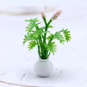 Vue détaillée d'une mini plante en pot de maison de poupée avec feuilles vertes et fleurs.