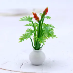 Plante en pot miniature pour maison de poupée avec feuilles vertes et fleurs rouges.