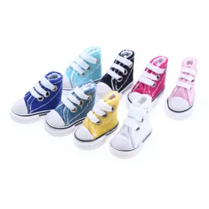 Dettaglio di mini scarpe di tela per bambole, colorate scarpe da ginnastica alte per giocattoli.