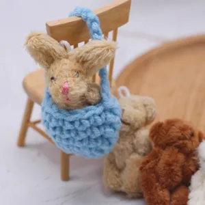 Détail en gros plan du lapin miniature au crochet dans son panier bleu avec accessoires ours.