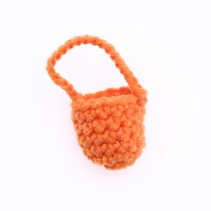 Dettaglio di mini borsa in lana lavorata all'uncinetto, accessorio carino per casa delle bambole.