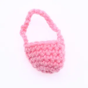 Dettaglio in primo piano di una mini borsa di lana rosa lavorata, accessorio per bambola BJD.