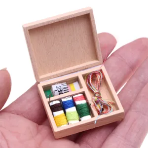 Miniature wooden sewing box dollhouse accessory featuring tiny colored threads and tape.