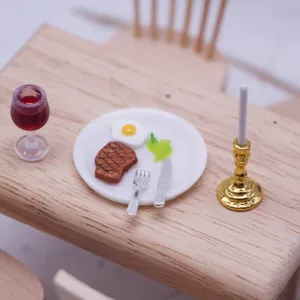 Miniature de maison de poupée set de table avec petit steak, verre de vin et bougeoir doré.