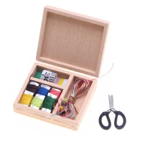Miniature wooden sewing box dollhouse accessory with colorful threads and tiny scissors.