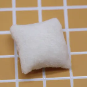 Mini coussin en peluche blanc detail shot, ideal pour accessoire decoration de canape.