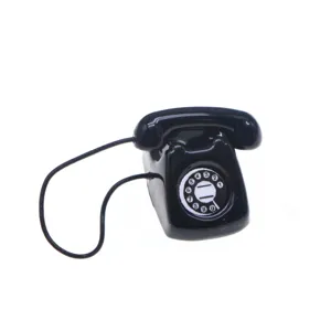 Miniature black rotary telephone detail shot, vintage dollhouse furniture prop and scene ornament.