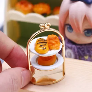 Détail de présentoir à dessert en métal pour maison de poupée, accessoire miniature idéal.