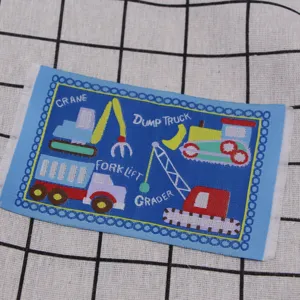 Miniature construction vehicle embroidered carpet detail for dollhouse scene decoration.