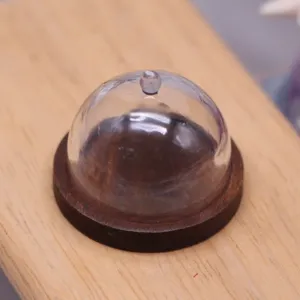 Miniature transparent dollhouse cake dome with dark base, perfect for food play scenes and display details.