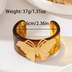 Primo piano dettagliato dell'elegante bracciale in resina con dettaglio farfalla dorata.