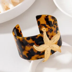 Bracciale rigido largo in resina con ciondolo a stella Marina dorata per stile da spiaggia.