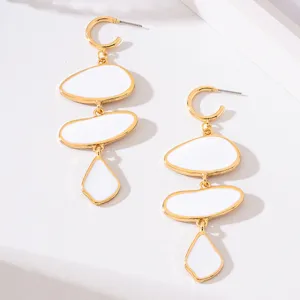Gold-plated dangle earrings featuring elegant white enamel irregular oval charms.