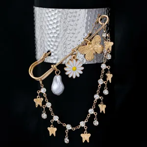 Gold safety pin cuff bracelet with pearl butterfly daisy charms and rhinestone tassels y2k style