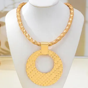 Vue rapprochée du collier statement doré texturé épais avec grand pendentif rond et creux.