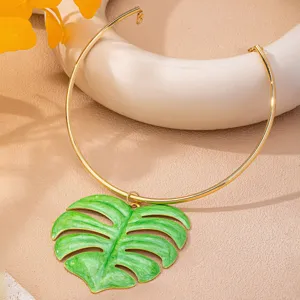 Collier ras du cou en métal doré avec pendentif feuille de monstera vert vif bijou tropical.