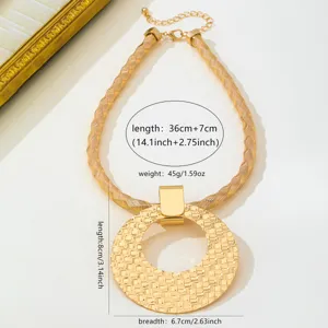 Collier ras de cou tissé doré avec grand pendentif rond ajouré texturé pour femme élégante.