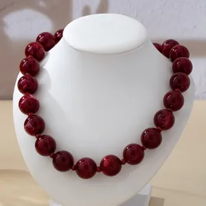 Collana con perle rosso scuro stile vintage dettaglio per elegante abito da sera.