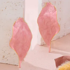 Primo piano di orecchini a foglia rosa astratti con bordo dorato, design retrò in smalto.