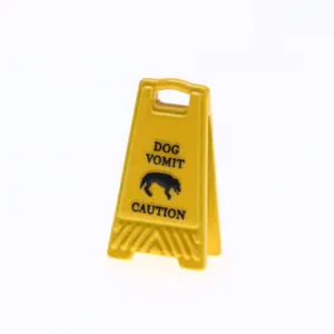 Miniature yellow caution sign detail view, funny novelty dollhouse prop for scene decoration.