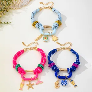 Vue détaillée de bracelets tressés style océan colorés avec pendentifs étoile de mer et poissons.