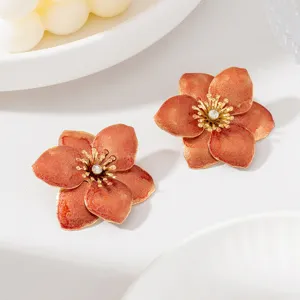 Gros plan détaillé de boucles d'oreilles fleurs émail rétro avec strass scintillants.