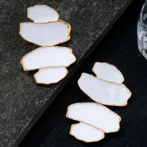 Boucles d'oreilles longues géométriques irrégulières à gouttes blanches et bordées d'or.