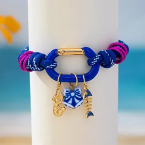 Gros plan du bracelet coloré en corde style marin avec des pendentifs sirène et arête de poisson.