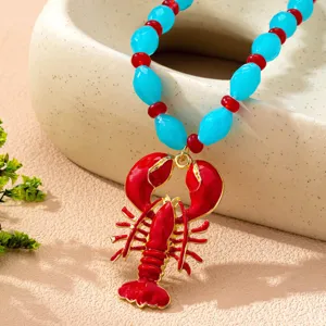 Primer plano de un collar colgante de langosta de verano con cadena de cuentas azules y rojas.