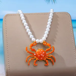 Vista detallada del colgante de cangrejo naranja estilo playa con collar de perlas fina