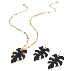 Set collana e orecchini a foglia di monstera nera con catena dorata moda donna.