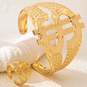 Gold dollar sign jewelry detail, featuring textured metal finish, chic hip-hop cuff & ring set.