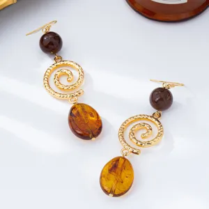 Vintage French style long amber pendant earrings with hammered gold spiral and dark beads.