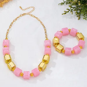 Set collana e bracciale di perle in acrilico rosa e cubi metallici dorati per l'estate.