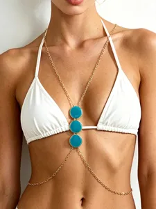 Detailed shot of gold-tone body chain featuring turquoise round enamel pendants for beach style.