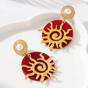 Boucles d'oreilles soleil vintage lourdes avec résine pailletée rouge et perle pour fête chic.