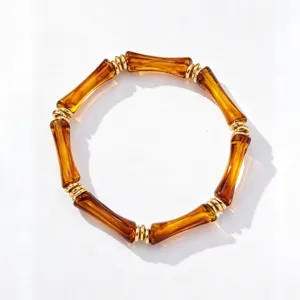 Retro amber acrylic bamboo segment bracelet with gold rings, stylish stackable chic wrist jewelry.