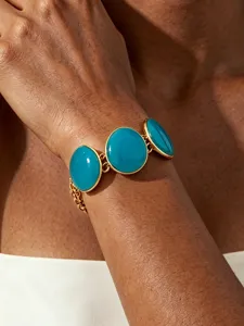 Gold-tone chain bracelet featuring vibrant turquoise enamel round discs for summer resort style.