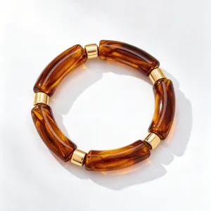 Close-up detail of the retro amber acrylic and gold metal bamboo segment bracelet design.