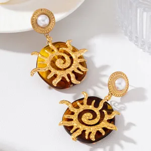 Boucles d'oreilles soleil martelées dorées rétro avec perle et résine ambre pour fêtes.