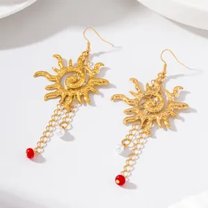 Boucles d'oreilles soleil martelées rétro avec chaînes, perles et perles rouges pour fêtes.
