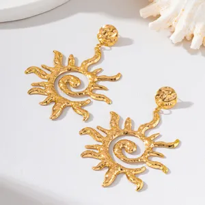 Boucles d'oreilles soleil dore texturees detail, parfait pour un style de vacances chic.