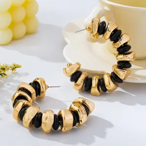 Detailed view of French retro irregular textured metal and black bead hoop earrings.