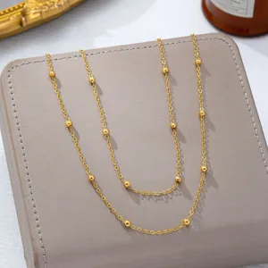 Detailaufnahme der goldenen Perlenkette, feine Metalltextur, elegantes Schmuckaccessoire.