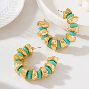 French vintage style C-shaped hoop earrings with gold textured metal and turquoise beads detail.