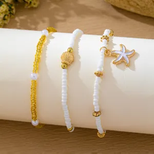 Vue detaillee de l'ensemble de bracelets de perles coquillage et etoile de mer boheme.