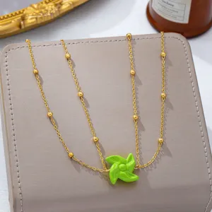 Goldene Perlenkette mit grünem Windmühlen-Anhänger, Detailansicht für Strandurlaub.