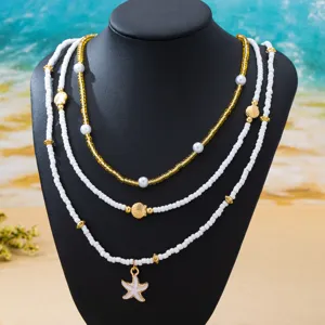 Collier de perles multicouche bohème avec pendentifs étoile de mer et coquillage de plage.