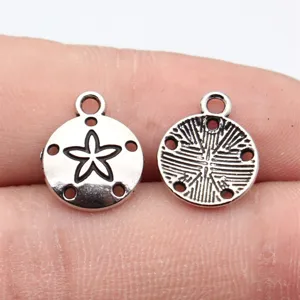 Close-up of silver-colored blackened sand dollar metal charm pendant for DIY jewelry making.